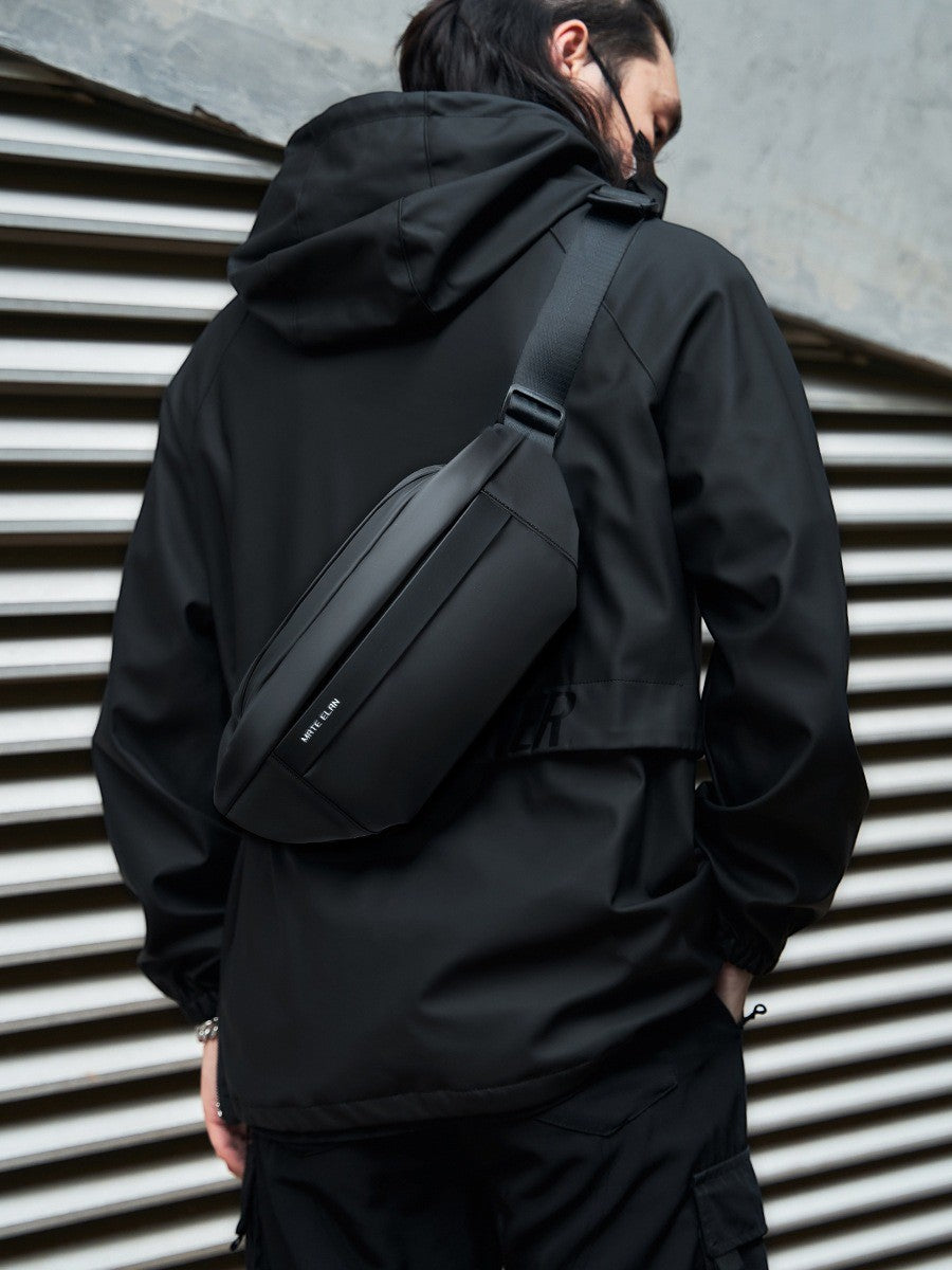 Crossbody väska i vattentåligt material, flera fack